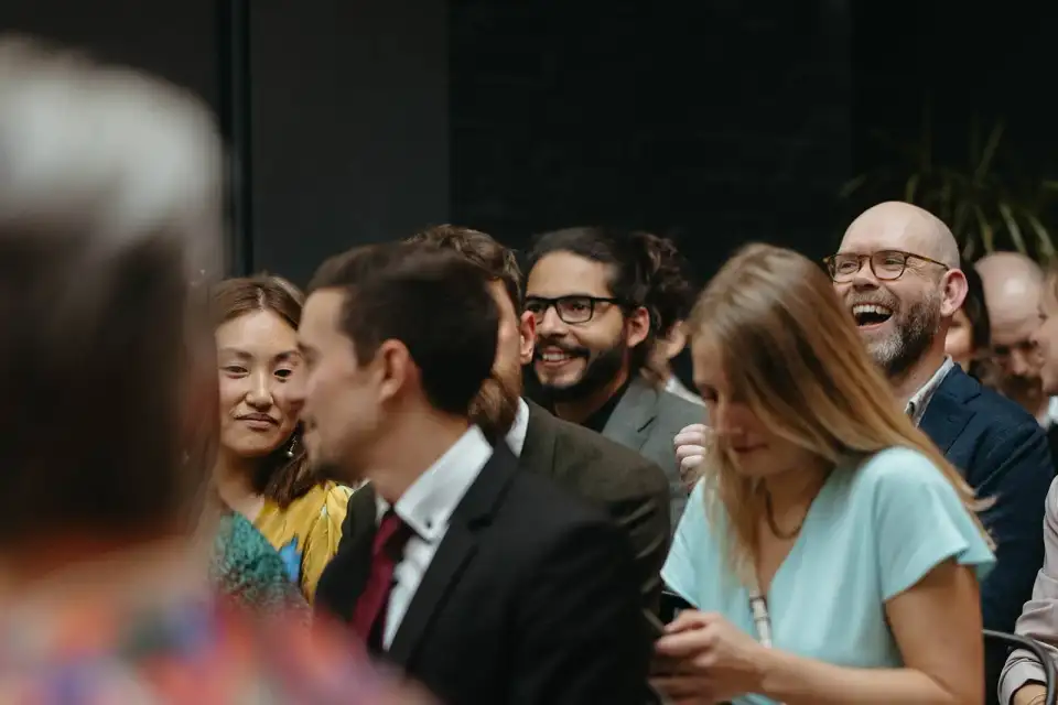 Guests laughing in their seats during a wedding ceremony