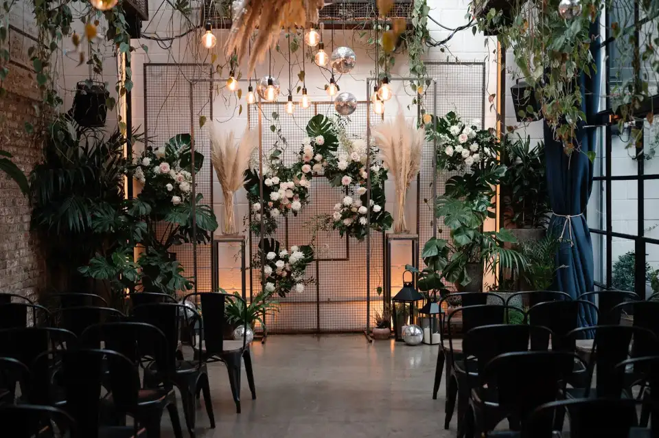 A ceremony aisle arch of greenery and white flowers.