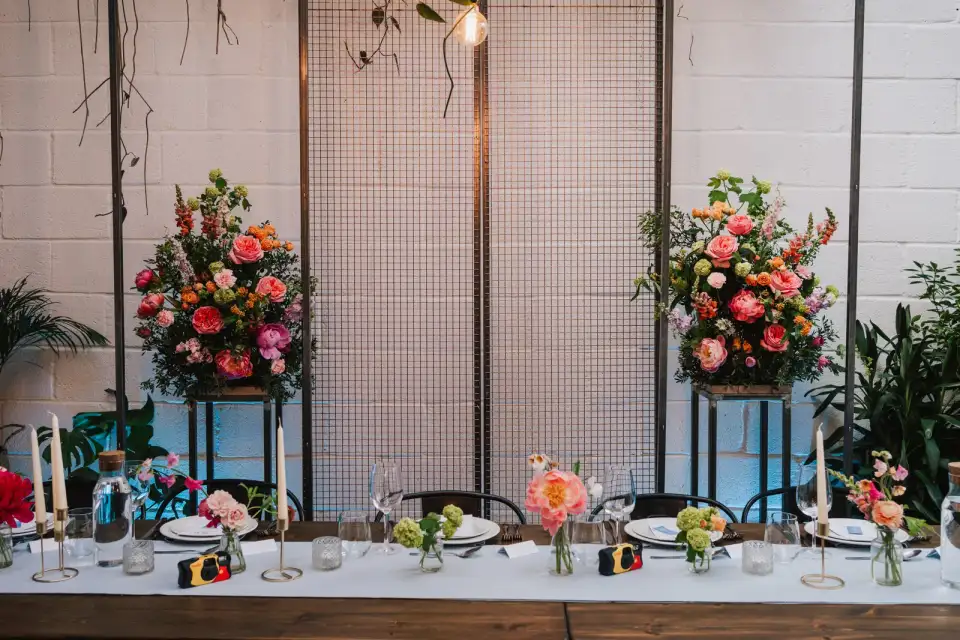 Twin pedestal floral arrangements flanking a dressed table.