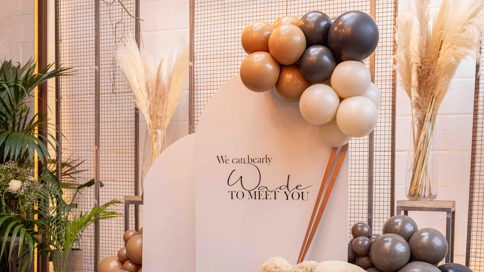 A balloon garland and giant teddy bear backdrop set up for a baby shower at The Hackney