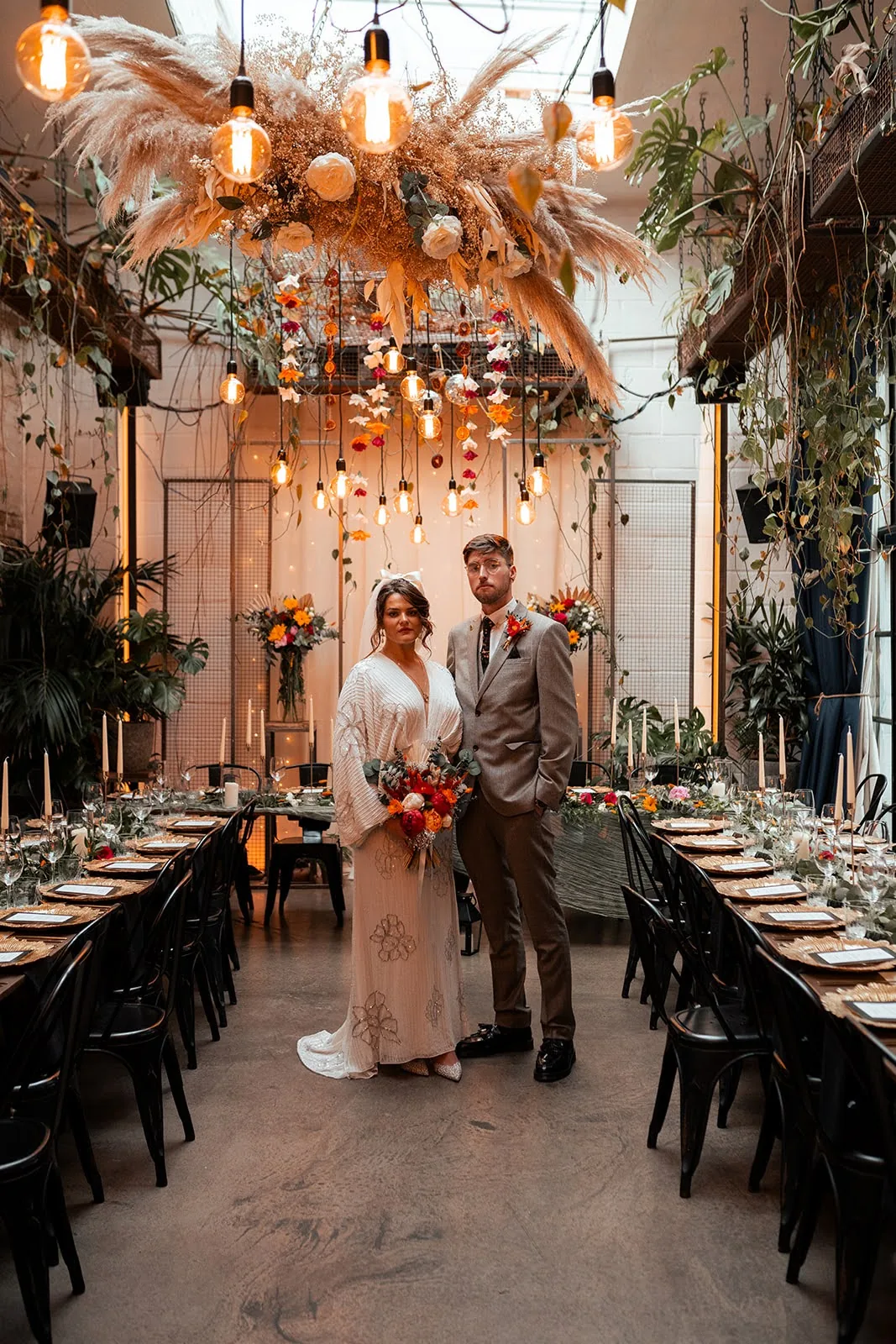Long wedding tables with Edison bulbs and exposed brick at The Hackney, a brewery wedding venue in East London