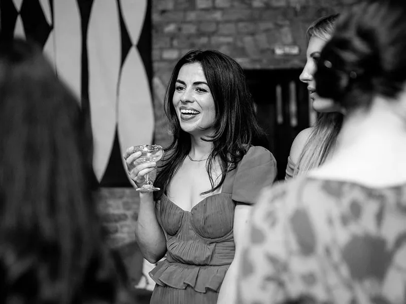A guest laughing with a cocktail at a private celebration at The Hackney